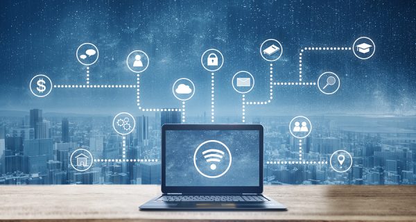 Computer laptop on wooden desk with wireless and application programming and social media icons. Internet networking and wireless technology